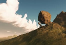 man pushing a boulder up a hill