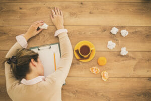 woman asleep on desk with cold, How to Get Rid of a Cold